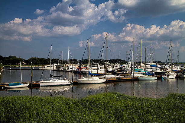 St Simon's Island Sailboat Marina This is the grasslands along the brackish water at St. Simon's Island Georgia USA with the sailboats in the background.  saint simons island photos stock pictures, royalty-free photos & images
