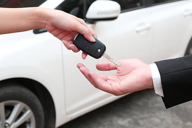 Female hand giving a key for buyer or rental car. stock photo