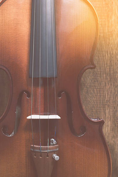 istock classical violin & amber light on wood background 495778550