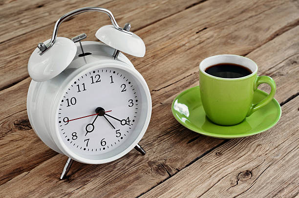 istock Green Cup of espresso with an white alarm clock 495778938