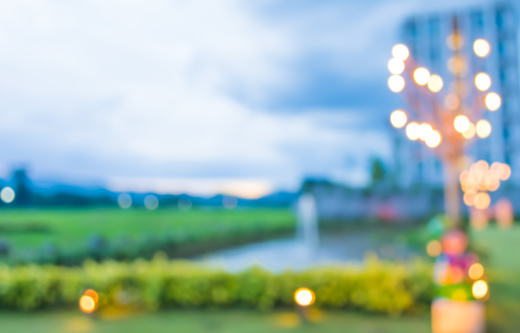 image of blur green field , pond and building with bokeh on evening time for background usage .