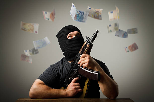 homme avec une arme à feu et des billets en euros. - currency crime gun conflict photos et images de collection