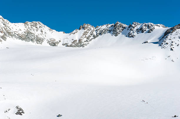 istock Panoramic view over a snowy slope with hikers 495782978