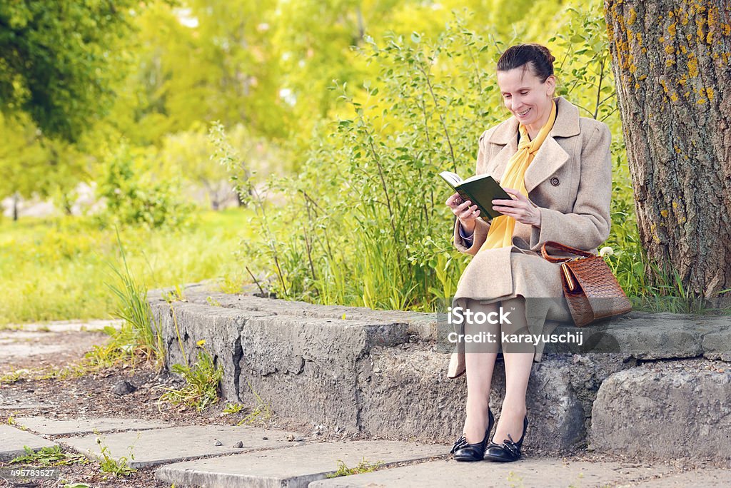 Donna leggendo un libro nel parco - Foto stock royalty-free di Adulto