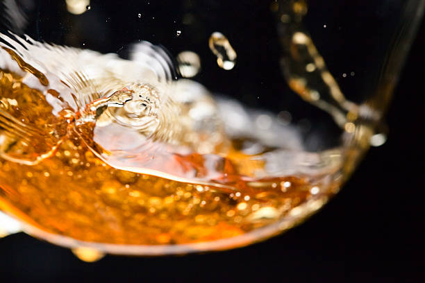detail of an alcoholic beverage detail of an alcoholic beverage on black background cognac brandy photos stock pictures, royalty-free photos & images