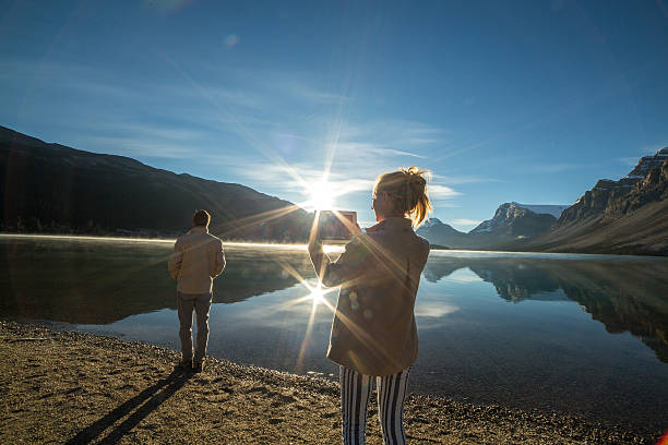 istock Couple by the lake at sunrise using digital tablet 495785990