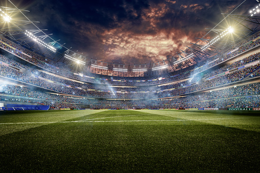 A wide angle of a outdoor soccer stadium full of spectators under a dramatic stormy evening sky at sunset. The stadium features fake advertising and generic scoreboards. The image has depth of field with the focus on the foreground part of the pitch. With intentional lensflares.