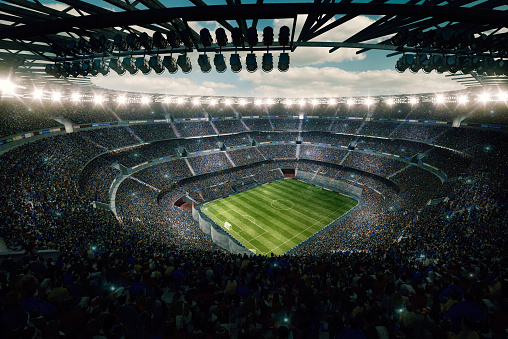 View from the upper tribunes to the soccer stadium full of spectators and lenseflares.