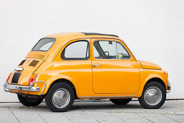 small orange vintage Italian car, Fiat 500, Tuscany, Italy