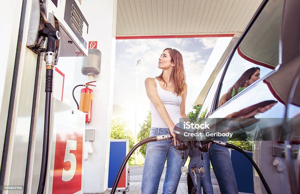 Pretty young woman refuel the car Refueling Stock Photo