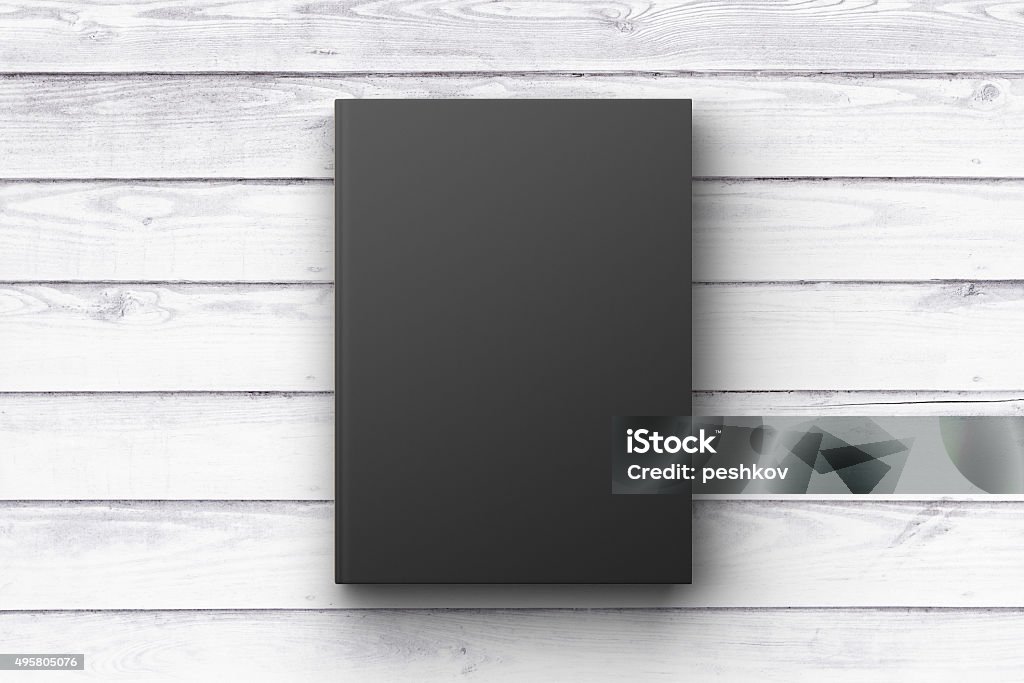 Black book cover on a white wooden surface, mock up 2015 Stock Photo