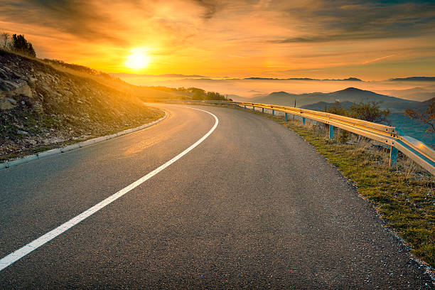 istock Driving on mountain road against the rising sun 495806050