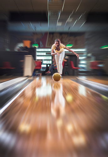 Young woman hitting a bowling ball