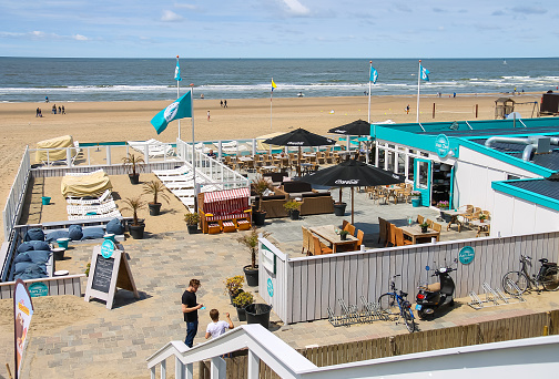 Zandvoort, the Netherlands - June 20, 2015:  Two young man in beach cafe terrace near the North sea.