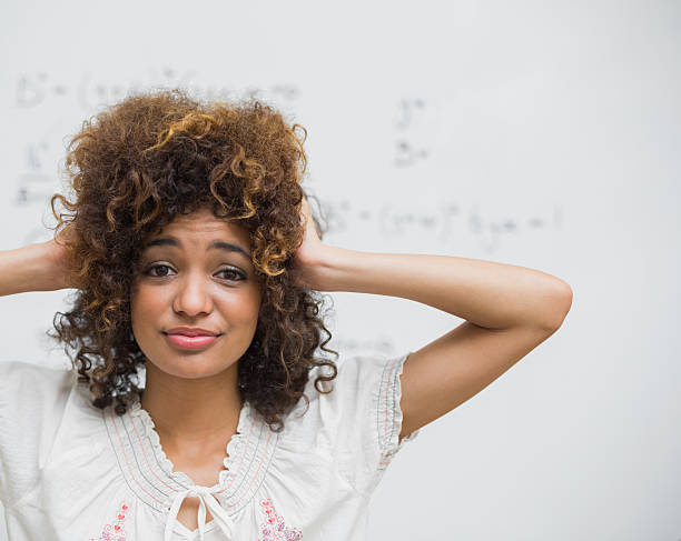 istock Confused student looking at camera in front of whiteboard 495812689
