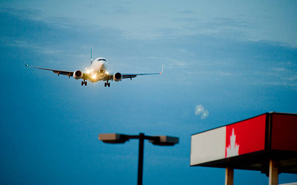 istock passenger plane fly down over take-off runway from airport 495813509