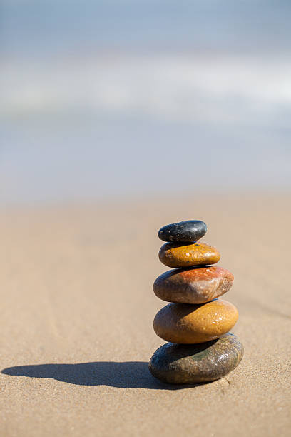 istock Stones pyramid on sandy beach symbolizing zen, harmony, balance. 495814059