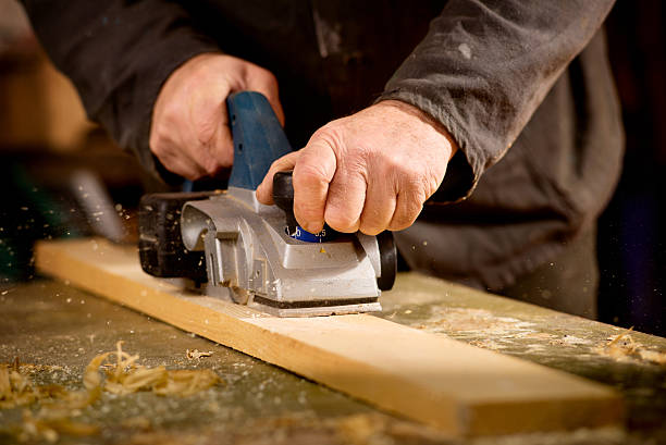 istock Elderly man planing a plank of wood 495816737