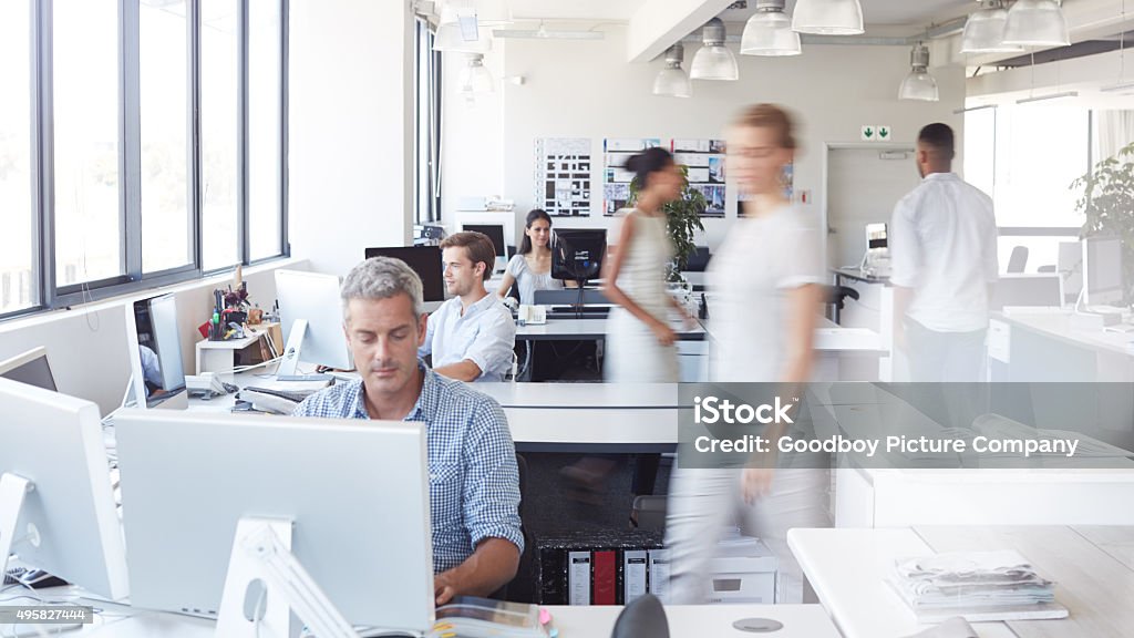 Go the extra mile, it's never crowded Shot of a man working at his desk with his colleagues blurred in the backgroundhttp://195.154.178.81/DATA/i_collage/pu/shoots/805874.jpg Office Stock Photo