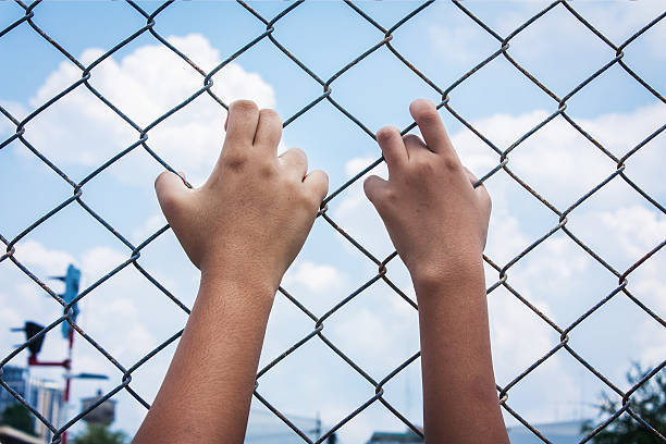 istock asian girl hand hold jail 495828732