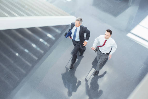 istock Businessmen with suitcases running in lobby 495829585
