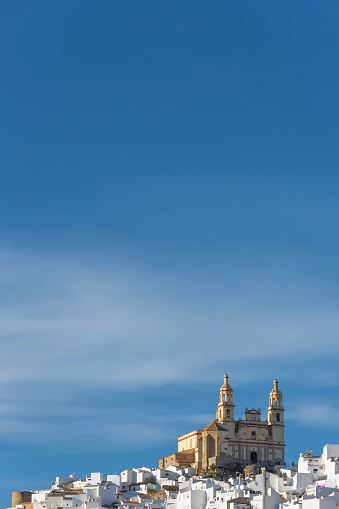 Parroquia de Nuestra Señora de la Encarnación en la cima de una colina bajo el cielo azul, Olvera, AndalucÕa, España photo