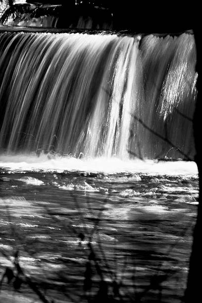 istock Flowing river, small waterfall in black and white. 495831506