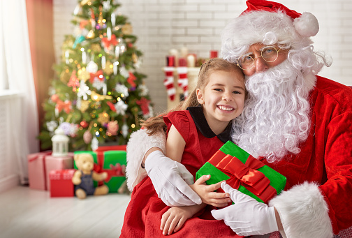 Santa Claus giving a present to a little cute girl