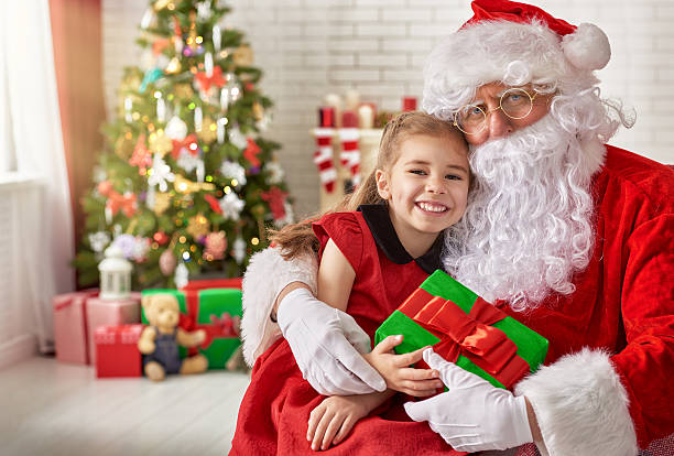 Santa Claus and little girl Santa Claus giving a present to a little cute girl santa claus photos stock pictures, royalty-free photos & images