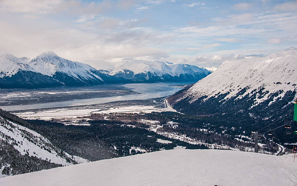 Alyeska Winter Wonderland Dramatic View Alyeska Winter Wonderland Dramatic View of the winter scene at Alaska's best ski resort. Alyeska. the town of Girdwood below in the valley waiting for some down time after skiing  chugach mountains photos stock pictures, royalty-free photos & images