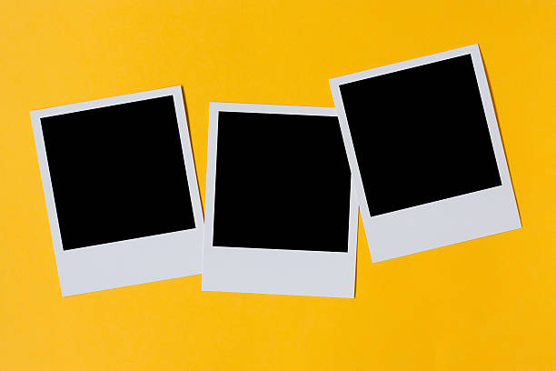 Polaroid photo prints isolated on yellow stock photo