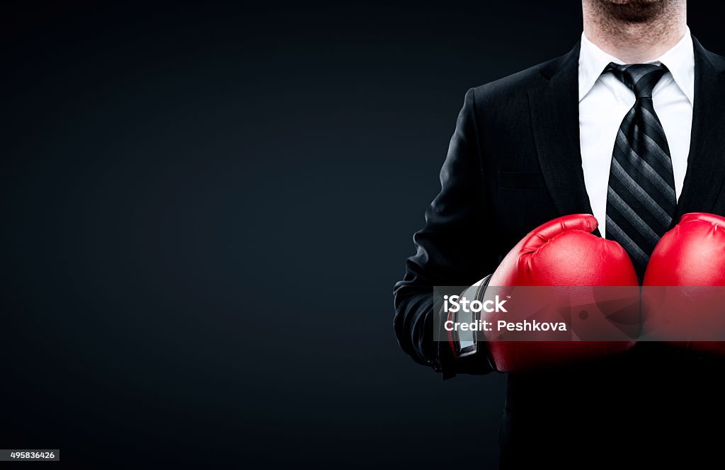 businessman in boxing gloves businessman in boxing gloves isolated on black background Boxing - Sport Stock Photo