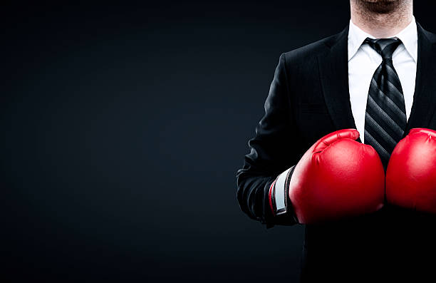 businessman in boxing gloves businessman in boxing gloves isolated on black background knockout stock pictures, royalty-free photos & images