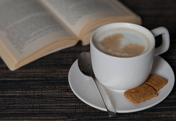 istock morning coffee with milk foam , cookie and book 495836846