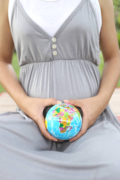 istock Pregnant women show Globe model in hand. 495837322