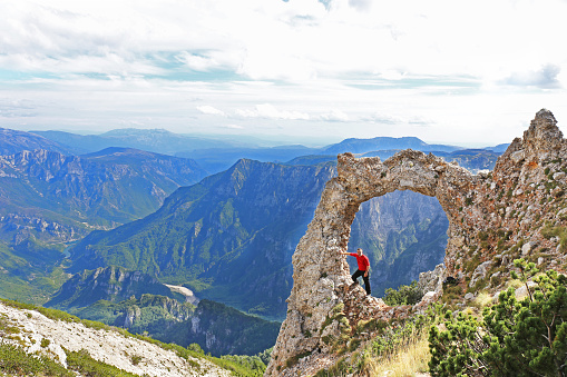 Hiker in mountain stone gate at mountain Cvrsnica, Bosnia and Hrzegovina