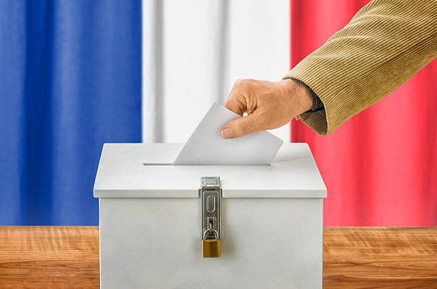 istock Man putting a ballot into a voting box - France 495841604