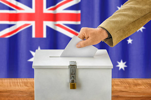 istock Man putting a ballot into a voting box - Australia 495841692