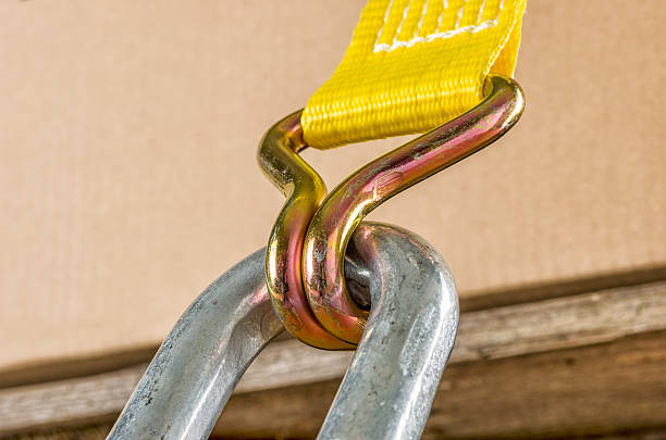 Load securing with a ratchet strap Load securing with a ratchet strap restraining device stock pictures, royalty-free photos & images