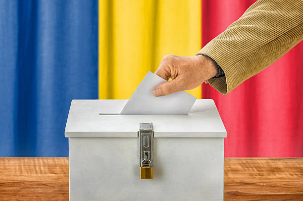 istock Man putting a ballot into a voting box - Romania 495842000