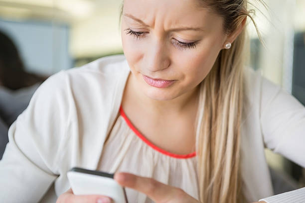 istock Young businesswoman text messaging through cell phone in office 495856389