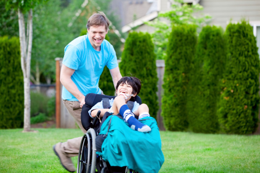 Father running with disabled son in wheelchair