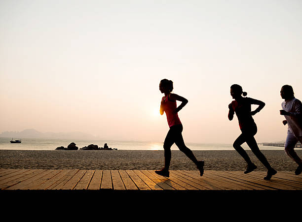istock Young women jogging along beach 495869948