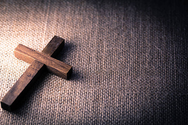 Holy Wooden Christian Cross An aerial view of a holy wooden Christian cross on a burlap background. burlap photos stock pictures, royalty-free photos & images