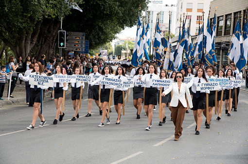 Nicosia, Cyprus - October 28, 2015:  Female students with their school uniforms holding Greek flags and posts with Cyprus village names parading during the celebrations of the 28 of October in Nicosia Cyprus.