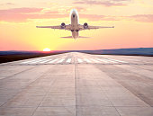 passenger airplane taking off at sunset