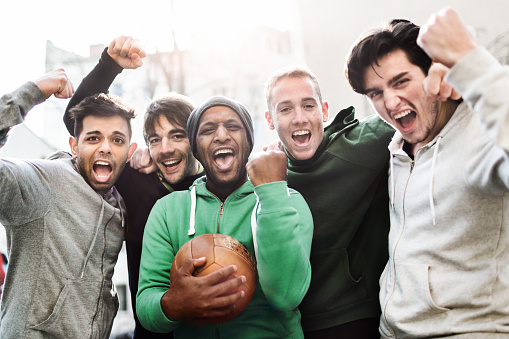 Group of young exciting soccer players screaming at camera