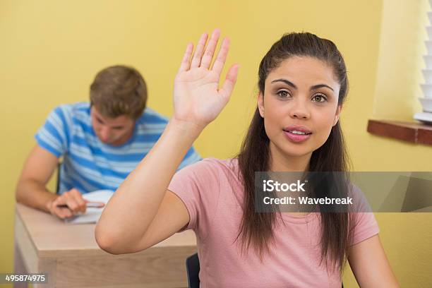 Attractive Young Student Raising Her Hand During Class Stock Photo - Download Image Now