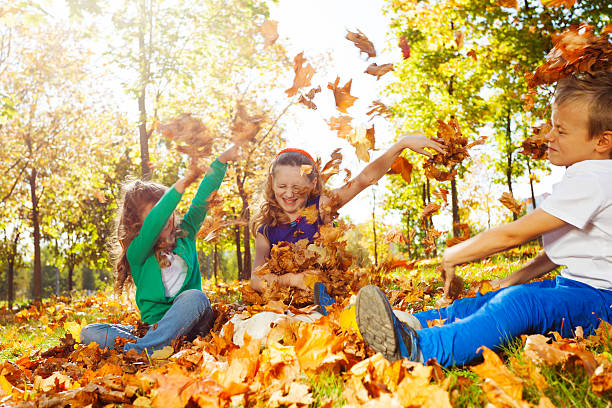 istock Happy friends having fun with thrown leaves 495879254