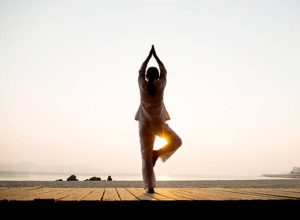 istock Woman in yoga pose at beach 495879318